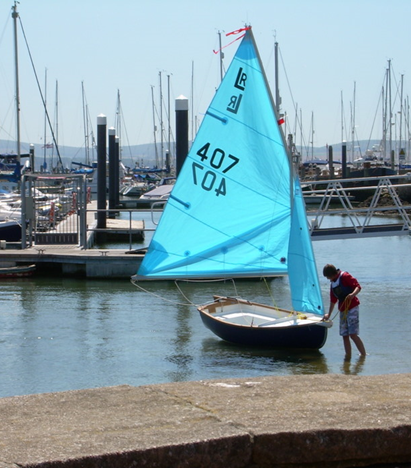 Small sailing boat with blue sails